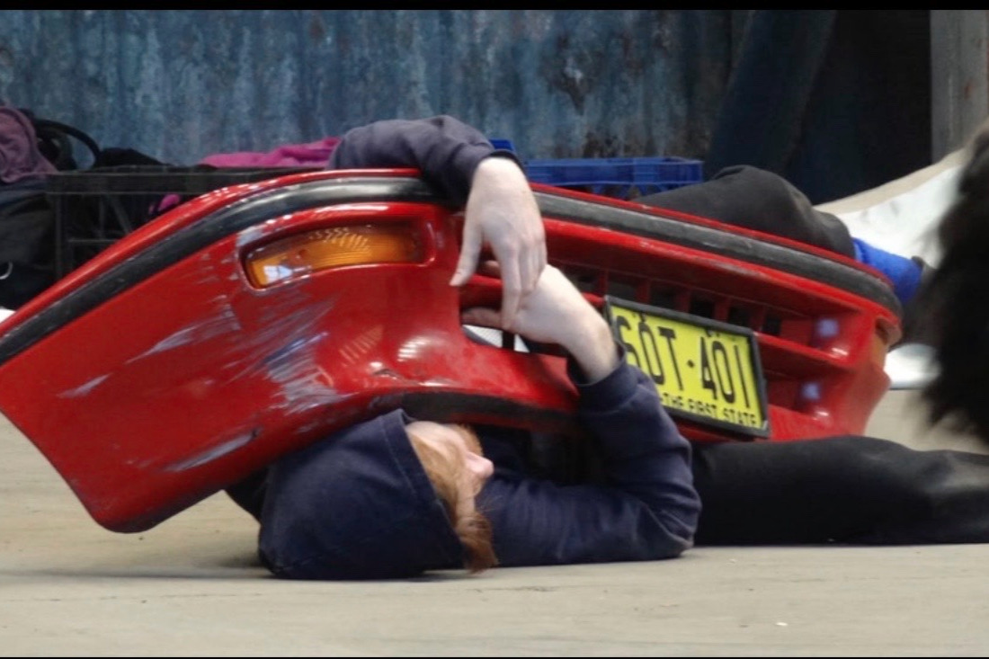 Andante workshop scene with performer under a red car